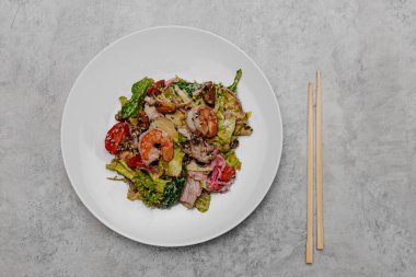 Gri arka planda deniz mahsullü salata. Yukarıdan görüntüle.