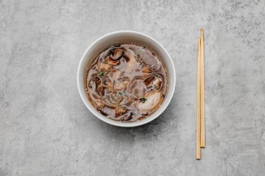 Gri arka planda karidesli Udon çorbası. Yukarıdan görüntüle.