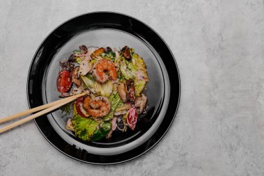 Gri arka planda deniz mahsullü salata. Yukarıdan görüntüle.