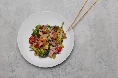 Gri arka planda deniz mahsullü salata. Yukarıdan görüntüle.