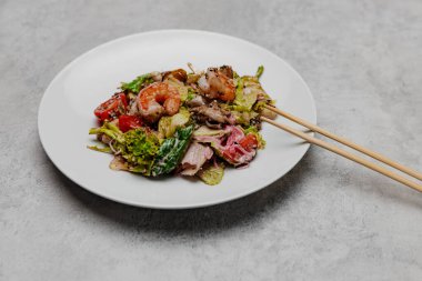 Gri arka planda deniz mahsullü salata. Yan görünüm.