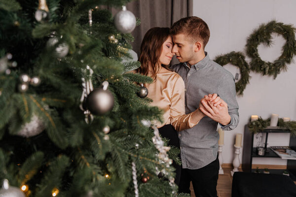 Young couple in love decorating the Christmas tree together