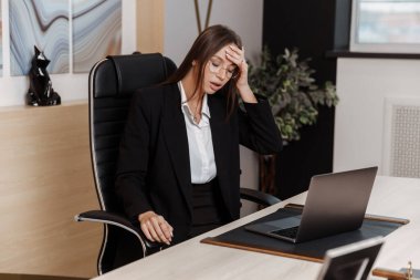 Tired stressed young business woman suffering from headache at work. Upset sick  lady massaging head feeling migraine from overwork using computer at  office.