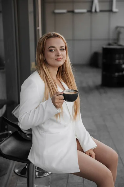 Blonde Stilvolle Frau Übergroßer Weißer Jacke Trinkt Aromakaffee Und Entspannt — Stockfoto