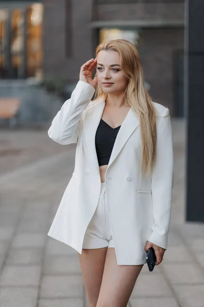 Blond Stijlvolle Vrouw Oversized Witte Jas Poseren Achtergrond Van Stad — Stockfoto