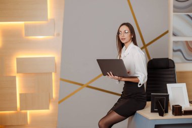 Close up Portrait of a young  businesswoman working on a laptop in an office