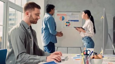 Yaratıcı Ofis 'te bilgisayar üzerinde çalışan adam. Kız ve Hintli Adam Ofiste Sunum Konuşuyor. Yaratıcı Ofis Çalışması.