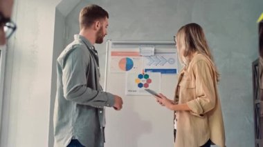 Man Working on PC in Creative Office. Woman and Man Discussing Presentation in Office. Creative Office Work.