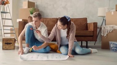 Couple Discussing Flat Plan. Couple Moving in new Home.