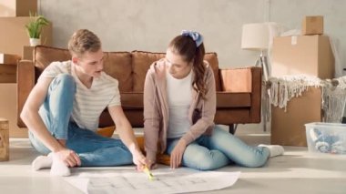 Couple Discussing Flat Plan. Couple Moving in new Home.