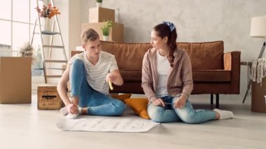 Couple Discussing Flat Plan. Couple Moving in new Home.