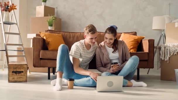 夫妻在一个新的家庭使用笔记本电脑 夫妇使用笔记本电脑购物 讨论内部 女孩在屏幕上指指点点 — 图库视频影像