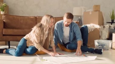 Couple Discussing Flat Plan. Couple Moving in new Home.