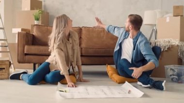 Couple Discussing Flat Plan. Couple Moving in new Home.
