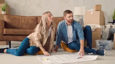 Couple Discussing Flat Plan. Couple Moving in new Home.