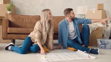 Couple Discussing Flat Plan. Couple Moving in new Home.