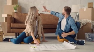 Couple Discussing Flat Plan. Couple Moving in new Home.
