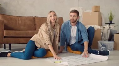 Couple Discussing Flat Plan. Couple Moving in new Home.