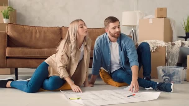Couple Discussing Flat Plan Couple Moving New Home — Vídeos de Stock