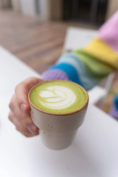 Manos Hombre Sosteniendo Macha Latte Cup Con Placa Madera Caffe Imagen de archivo