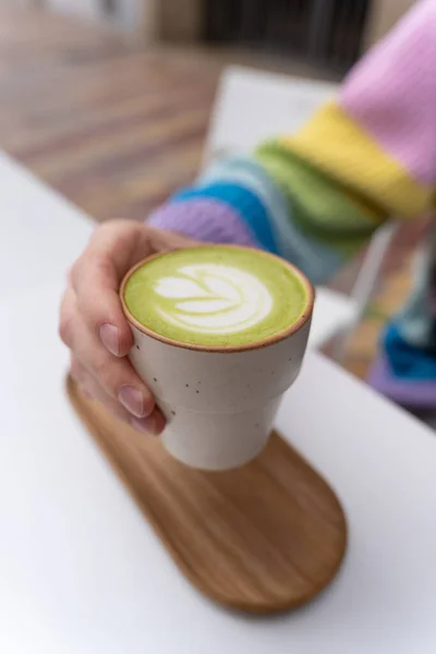 Manos Hombre Sosteniendo Macha Latte Cup Con Placa Madera Caffe Fotos de stock
