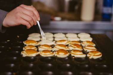 Küçük krepler pişiren kız.