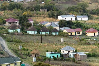 Port St Johns 'dan Doğu Londra' ya vahşi sahil gezisi. Renkli rondavel kulübeleriyle kaplı yuvarlanan yeşil tepeleri olan karakteristik köylerden geçiyoruz.