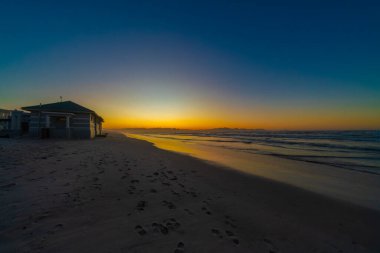 Cape Town, Güney Afrika 'daki Muizenberg plajında renkli sahil evleri ya da sahil kulübeleri.