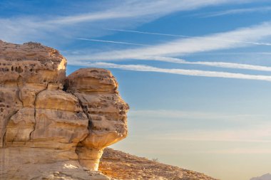 Gün batımında Face Rock, Suudi Arabistan 'ın Alula çölünde, Hegra' nın antik mezarları Cebrail Alahmar 'ın oyulmuş kumtaşı kayasının yanındaki doğal merak.