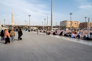 Medine, Suudi Arabistan - 18 Aralık 2024: Medine 'deki Büyük Kral Abdullah Camii' nin dev şemsiyeleri altındaki hacılar, Suudi Arabistan 'ın ikinci en kutsal İslam mekanı.