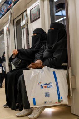 Riyad, Suudi Arabistan - 22 Aralık 2024: Riyad, Suudi Arabistan 'ın modern metro sistemindeki yolcular, şehrin kentsel manzarasını değiştiren yeni toplu taşıma sistemi