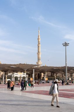 Medine, Suudi Arabistan - 18 Aralık 2024: Medine 'deki Büyük Kral Abdullah Camii' nin dev şemsiyeleri altındaki hacılar, Suudi Arabistan 'ın ikinci en kutsal İslam mekanı.