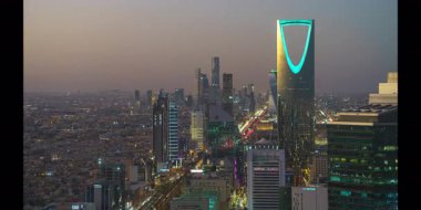 Faisaliah Kulesi 'nin tepesinden, Suudi Arabistan' ın ikonik Krallık Merkezi 'nin hakim olduğu Riyad şehrinin günbatımı manzarası.