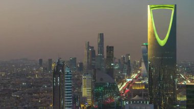 Faisaliah Kulesi 'nin tepesinden, Suudi Arabistan' ın ikonik Krallık Merkezi 'nin hakim olduğu Riyad' ın ufuk çizgisinin günbatımı görüntüsü nefes kesici bir zaman dilimi.