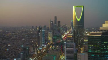 Faisaliah Kulesi 'nin tepesinden, Suudi Arabistan' ın ikonik Krallık Merkezi 'nin hakim olduğu Riyad' ın ufuk çizgisinin günbatımı görüntüsü nefes kesici bir zaman dilimi.