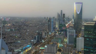 Faisaliah Kulesi 'nin tepesinden, Suudi Arabistan' ın ikonik Krallık Merkezi 'nin hakim olduğu Riyad' ın ufuk çizgisinin günbatımı görüntüsü nefes kesici bir zaman dilimi.
