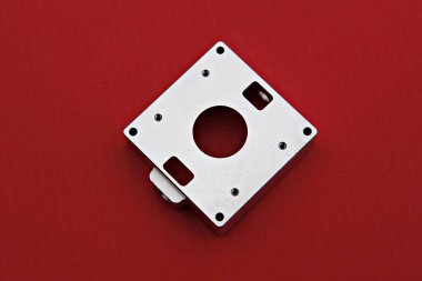 kırmızı bir yüzeyde metal bir nesne