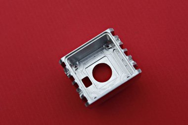 Kırmızı bir yüzey üzerinde bulunan metal bir aygıt