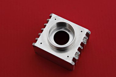 Kırmızı bir yüzeyde metal bir cihaz