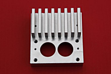 Kırmızı yüzeyinde dört deliği olan metal bir cihaz.