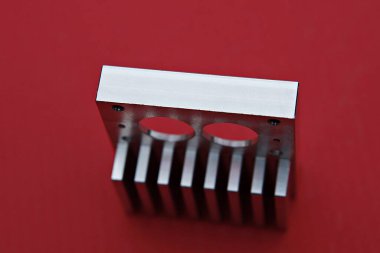 kırmızı bir yüzey üzerinde metal bir nesneye yakın çekim