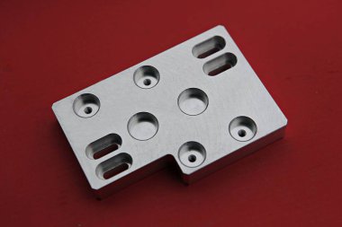 kırmızı bir yüzeyde metal bir nesne