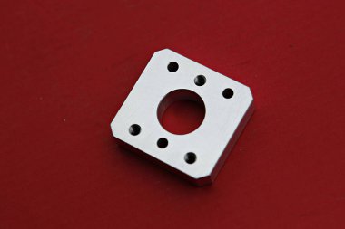 kırmızı bir yüzeyde metal bir nesne