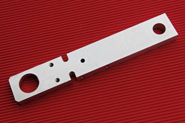 kırmızı bir yüzeyde metal bir nesne