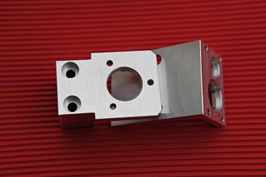 Kırmızı yüzeyinde delikleri olan metal bir nesne.