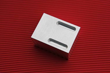 kırmızı bir yüzeyde metal bir nesne