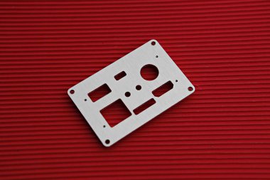 Kırmızı bir yüzeyde metal bir cihaz