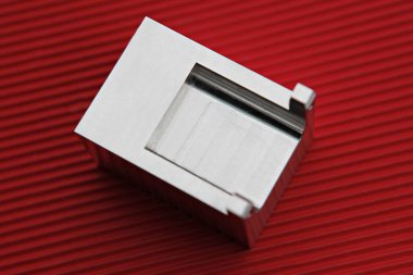 kırmızı bir yüzey üzerinde metal bir nesneye yakın çekim