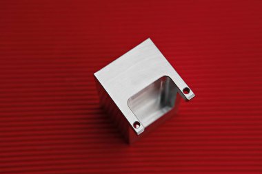 kırmızı bir yüzeyde metal bir nesne