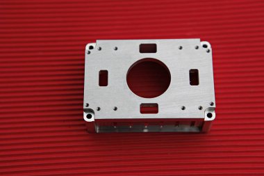 Kırmızı bir yüzeyde metal bir cihaz